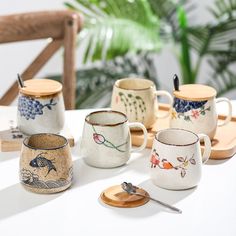 several coffee cups and spoons sitting on a table