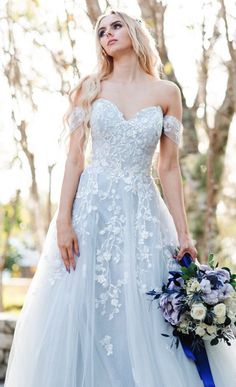 a woman in a wedding dress holding a bouquet