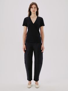 A sexier take on our classic, slightly sheer T-Shirt, the v-neck version skims the body and features a light kick at the sleeve. Pair with the Paper Bag Pleated Trouser to bring effortless balance to the more dramatic deep neckline. The fibers used to create our 100% organic cotton blend continue to soften with age. The GOTS production standards practiced by our partners ban the use of hazardous chemicals and help promote healthy soils, ecosystems, and working conditions. Part of The Foundation— Deep Neckline, Supima Cotton, The Foundation, V Neck Tee, Skirt Top, Deep V Neck, Black And Navy, Sustainable Fashion, Dresses For Sale