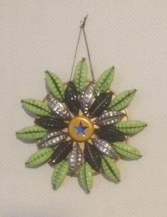 a green and black brooch hanging on a wall