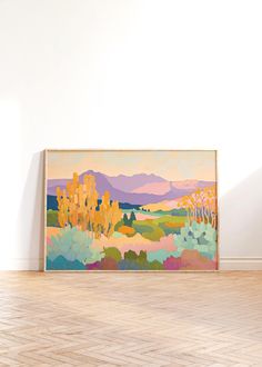 an abstract painting hangs on the wall above a hardwood floor