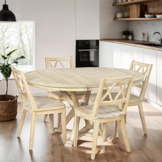 a wooden table and chairs in a room with white walls, wood flooring and open shelves