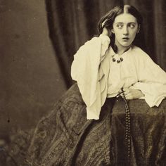 an old black and white photo of a woman sitting on a chair with her hands behind her head