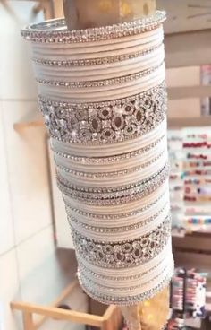 a person is holding a stack of bracelets in front of a store display case