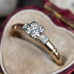 a diamond ring sitting on top of a velvet box