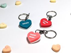 four heart shaped key chains with the words xoxo and sweet treats on them