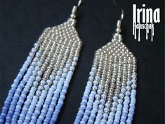 two tone beaded fringe earrings with silver and blue beads hanging from the ends, on a black background