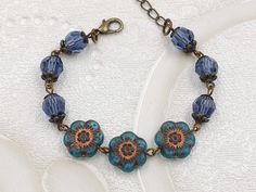 "This is the beautiful blue flower beaded bracelet. It is hand linked together with matte translucent blue Czech glass flower and denim blue crystals. The glass crystals are topped with floral lace filigree bead caps. It is suspended in lobster claw clasp closure along with bronze chain extender. The bracelet length is adjustable from 155mm (6.1 inches) to 205mm (8 inches).  It is a wonderful idea for gift giving and as a little treat for yourself. Your bracelet will presented in a gift box and tied with ribbon. Measurements and details: Length: 155mm (6.1\") - 205mm (8\") Flower: 12mm Crystal: 8mm Chain: Bronze Closure: Bronze lobster claw clasp See more jewelry and vintage treasures here: https://www.etsy.com/shop/thecharmjewelry" Blue Czech Glass Bracelets With Colorful Beads, Czech Glass Flower Jewelry With Colorful Beads, Czech Glass Beaded Flower Necklace, Blue Czech Glass Flower Jewelry, Colorful Flower-shaped Czech Glass Jewelry, Czech Beads Jewelry, Vintage Style Jewellery, Chain Extenders, Homemade Jewelry