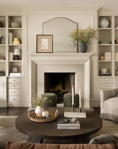 a living room filled with furniture and a fire place in front of a white fireplace