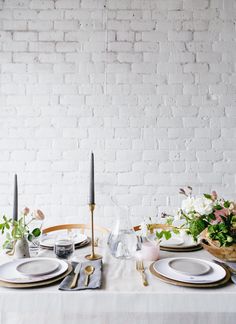 the table is set with white plates and silverware