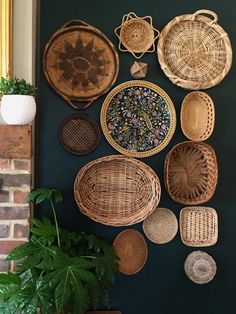 wicker baskets are hanging on the wall next to a potted plant