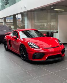 a red sports car is parked in a showroom