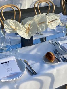 the table is set with silverware and flowers