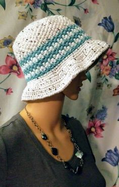 a mannequin head wearing a white and blue crochet hat with beads