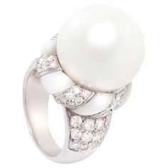 This South Sea pearl and diamond ring features a pearl of 16.5/17mm diameter. The pearl is untreated. It displays a splendid nacre and its natural color and luster have not been enhanced in any way. The pearl is perched on a crown of round diamonds with a mother-of-pearl ribbon, lending the jewel a distinctive art déco look. The total weight of diamonds is 1.54 carats. All diamonds are of top quality (F/G-VVS). The ring is one-of-a-kind. It was handmade in Italy by gran maestro Pasquale according to an original design by Ella Gafter. It features craftsmanship of the highest refinement. The item is signed EG. Luxury Mother Of Pearl Wedding Ring, Luxury Mother Of Pearl Rings For Wedding, Elegant Mother Of Pearl Round Rings, Classic Mother Of Pearl Ring For Formal Occasions, Classic Formal Rings With Mother Of Pearl, Elegant Round Mother Of Pearl Ring, Formal Mother Of Pearl Round Ring, Elegant White Gold Diamond Ring With Cabochon, Formal Round Mother Of Pearl Ring