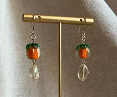 Whimsical glass persimmon and citrine dangle earrings on a 14kt gold plated hook. These earrings sway and twinkle in the light and radiate a warm glow. May they bring you longevity and good luck! Handmade with love in Boston, MA.  Glass beads are handmade so will have variations.  Please handle with care as the beads are delicate. Amber Earrings With Dangling Beads For Gift, Orange Citrine Earrings Gift, Unique Orange Glass Jewelry, Handmade Orange Citrine Jewelry, Orange Round Bead Earrings For Gifts, Cottage Core Vibes, Fruit Jewelry, Fruit Earrings, Citrine Earrings