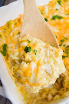 a spoon full of rice and vegetables being lifted from a casserole dish