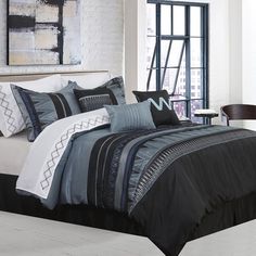 a bed with black and white comforters in a room