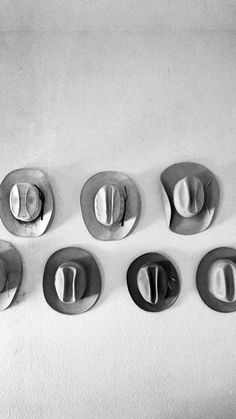 six hats are arranged in a row on the wall