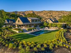 an aerial view of a house with a pool in the foreground and mountains in the background