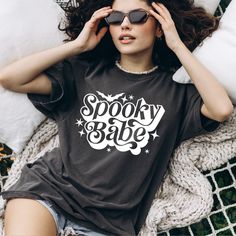 "Comfort Colors®, Spooky Babe Shirt, Halloween Women Gift, Vintage Retro Spooky Season, Trendy Spooky Vibes Shirt, Cute Halloween Tee, Boho Fall Autumn Shirt *ABOUT OUR TEES QUALITY -Printed by our professional printing machine.  * Comfort Colors 1717 Unisex Heavyweight Tee Features -6.1 oz./yd² (US), 10 oz/L yd (CA), 100% ring spun cotton, 20 singles -Garment-dyed soft ring spun fabric -Relaxed fit -Topstitched, classic width, rib collar -Twill taped neck and shoulders -Twill label *HOW TO  ORD Trendy Halloween Festival Tops, Halloween Festival Graphic Print Top, Vintage Distressed Tops For Halloween, Vintage Distressed Halloween T-shirt, Casual Halloween Festival T-shirt, Black Bohemian Top For Halloween, Black Bohemian Tops For Halloween, Witchy Women, Spooky Babe