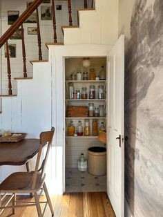 an open pantry in the corner of a room with wooden flooring and white walls