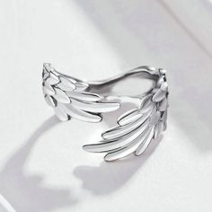 Our Wings Ring is designed for those who seek elegance and individuality.Inspired by the majestic wings of birds, this timeless accessory embodies a sense of empowerment and strength, making it the perfect statement piece for both men and women. Its sleek and minimalist design ensures versatility, allowing you to effortlessly pair it with any outfit, from casual to formal. Its wraparound design gracefully curves around your finger, providing a comfortable fit while exuding a sense of effortless Angel Wing Ring, Silver Certificate, Feather Ring, Silver Wings, Wholesale Gifts, Feather Jewelry, Finger Rings, 925 Jewelry, Sterling Silver Charm