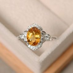 This halo ring features a 7*9mm oval cut natural citrine and sterling silver finished with rhodium. Customization is available. It is made by hand, and it will take about 7 days to finish the ring after your payment is completed. Main stone: genuine citrine Citrine weight: Approx 1.75 ct Metal type: sterling silver finished with rhodium Accent stone: cz Customization is available, I also can make it with 14k solid gold (white or yellow or rose) and diamond accent stone, just feel free to contact Citrine Engagement Ring, Yellow Citrine Ring, Citrine Ring Engagement, November Birthstone Ring, Yellow Engagement Rings, Ringe Gold, Citrine Ring, Natural Citrine, November Birthstone