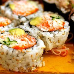 several sushi rolls on a wooden cutting board