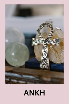 ankh cross sitting on top of a table next to crystals