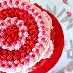 a red and white cake sitting on top of a plate