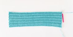 a piece of blue yarn with a pink tassel