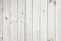 a white wooden wall with knots in the middle and wood planks at the top