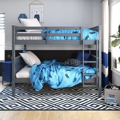 there is a bunk bed with blue sheets and pillows on the bottom bunk, next to a black and white chevron rug