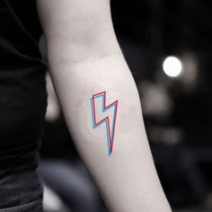 a woman's arm with a red and blue lightning bolt tattoo on the left forearm