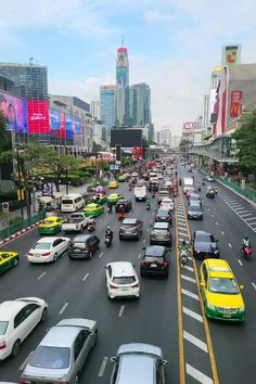 a busy city street filled with lots of traffic next to tall buildings and skyscrapers