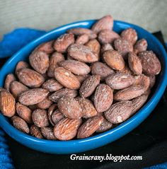 a blue bowl filled with almonds on top of a blue towel