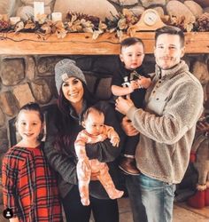 a family posing for a photo in front of a fireplace