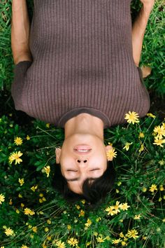 an overhead view of a person laying on the ground with daisies in front of them