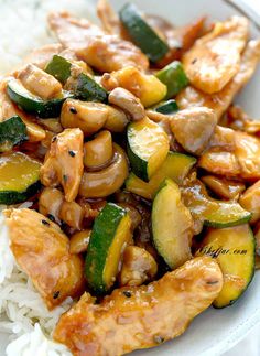 chicken and zucchini stir fry on rice in a white bowl, ready to be eaten