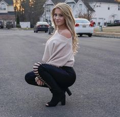 a woman kneeling down in the middle of a street