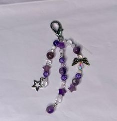 a purple and white beaded lanyard with an angel charm hanging from it's side