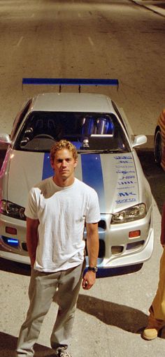 a man standing in front of a white car