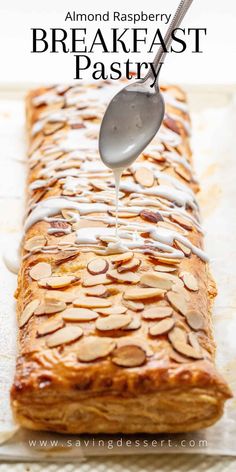 almond raspberry breakfast pastry is being drizzled with icing