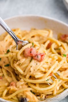 a fork full of pasta in a bowl