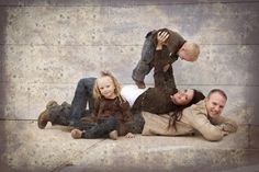 three people are laying on the ground with one woman and two children in their arms