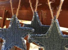 three blue stars hanging from strings on a wooden bench