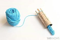 a blue ball of yarn next to a crochet hook on a white surface