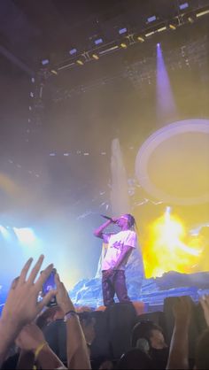 a man standing on top of a stage with his arms in the air