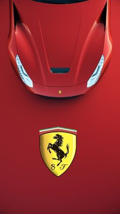 the front end of a red sports car with a ferrari emblem on it's hood